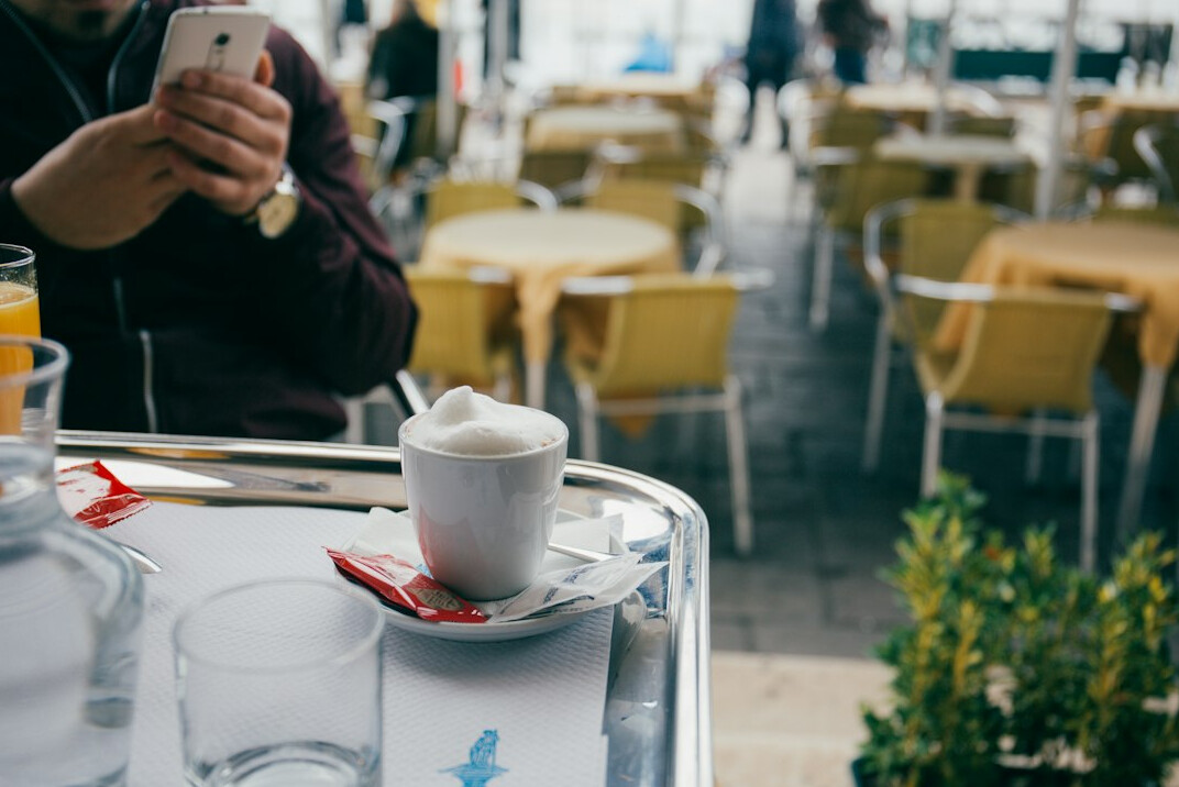 person using smartphone in cafe